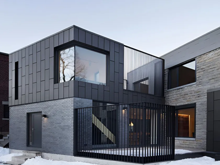 Charcoal rainscreen cladding meeting grey brick on a contemporary two-storey elevation